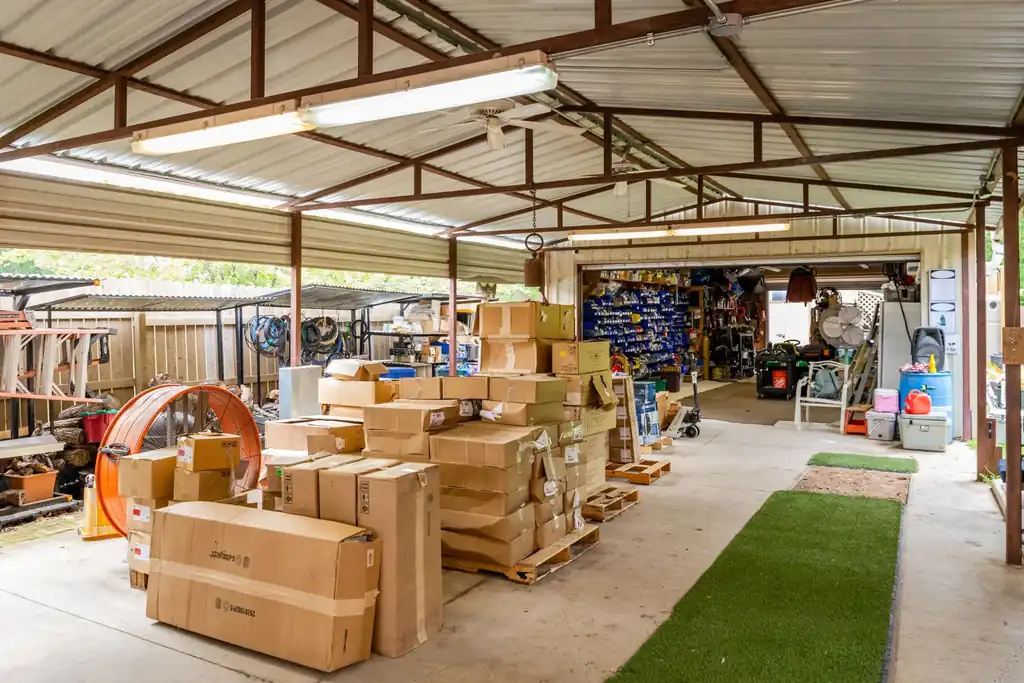 Interior of a covered warehouse and shop storage area with stocked electrical supplies and tools